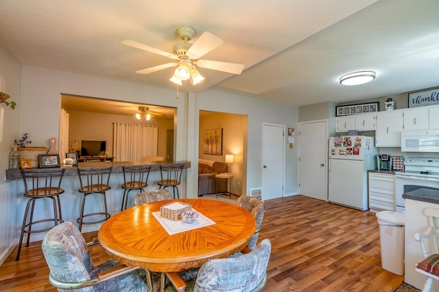 dining space with light wood-style floors and a ceiling fan