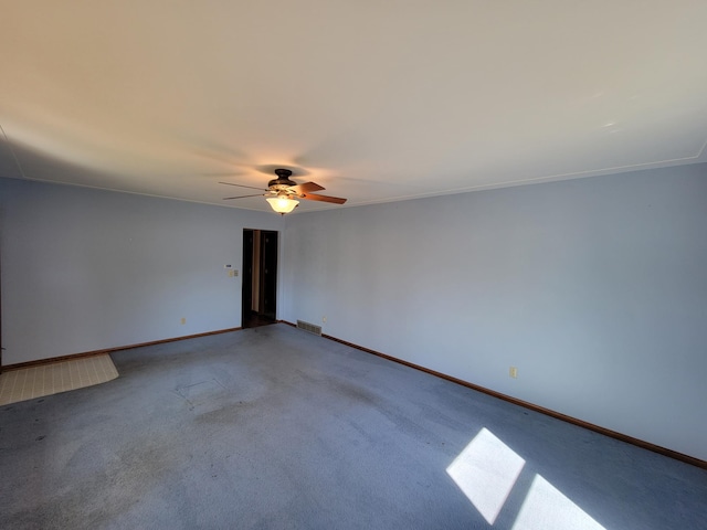 carpeted empty room with ceiling fan and baseboards