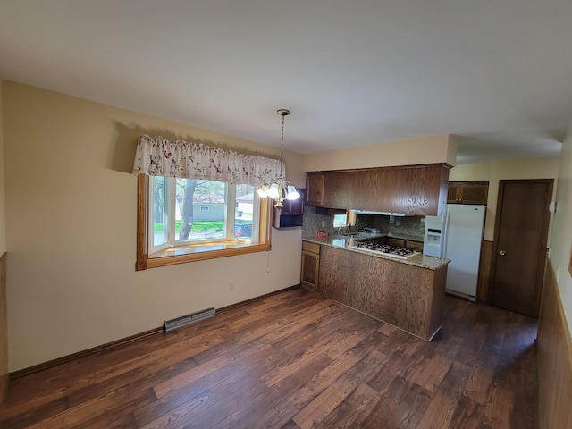 kitchen with white appliances, a peninsula, dark wood finished floors, backsplash, and pendant lighting