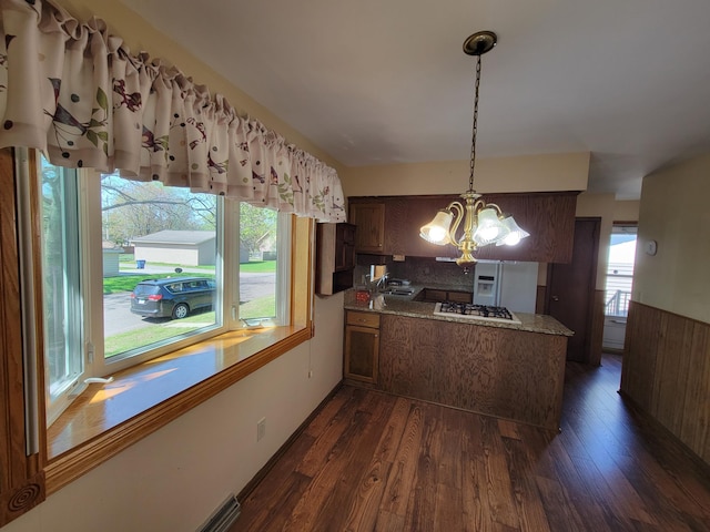 kitchen featuring a peninsula, a chandelier, white appliances, and dark wood finished floors