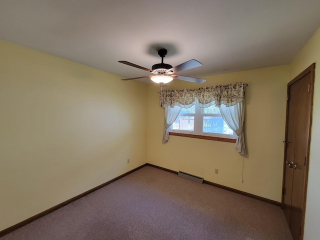 carpeted spare room with a ceiling fan and baseboards