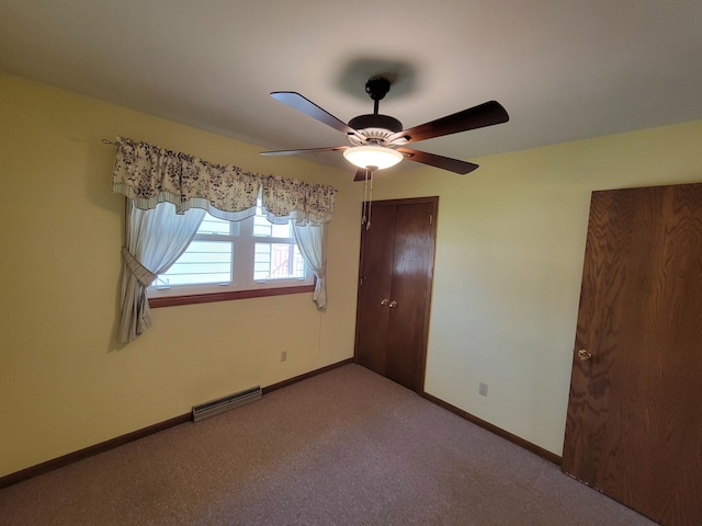 unfurnished bedroom featuring carpet floors, baseboards, and a ceiling fan