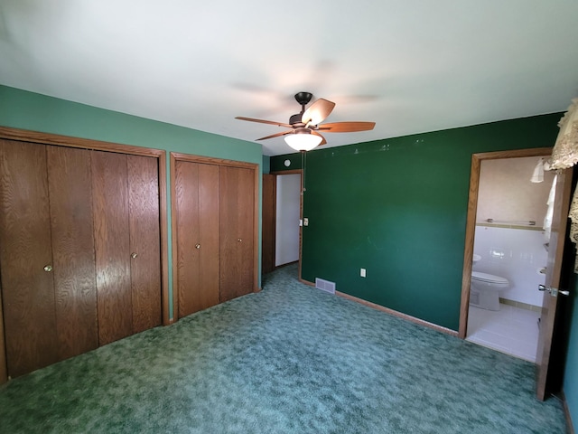 unfurnished bedroom with multiple closets, carpet floors, connected bathroom, baseboards, and a ceiling fan