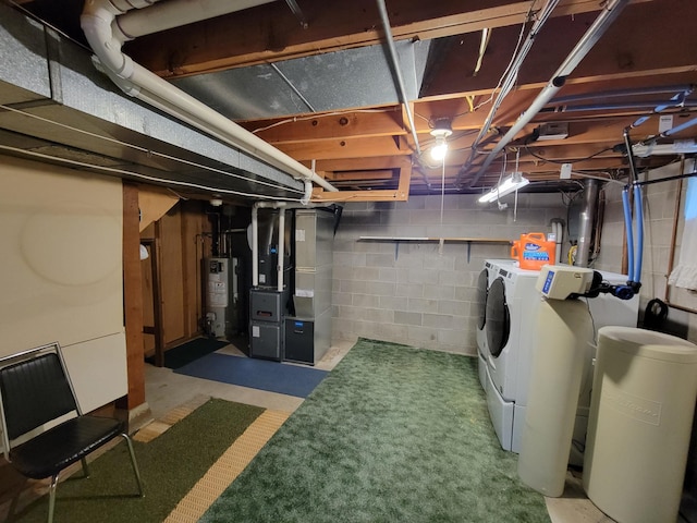 unfinished below grade area featuring separate washer and dryer, water heater, heating unit, and a water softener system