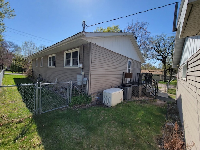 view of side of home with a gate and central AC