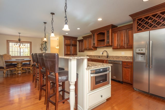 5123 Green Meadow Rd SE, Osakis, MN 56360 - kitchen featuring a center island, an inviting chandelier, appliances with stainless steel finishes, and light wood-style flooring