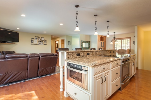 5123 Green Meadow Rd SE, Osakis, MN 56360 - kitchen with appliances with stainless steel finishes, light stone counters, open floor plan, and light wood-type flooring