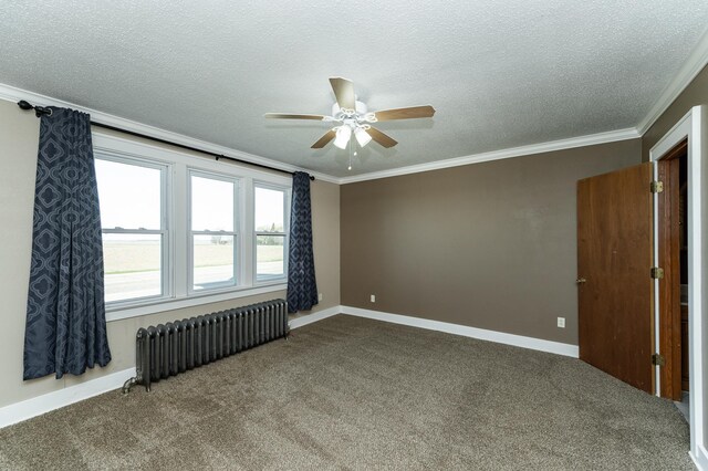empty room featuring radiator, a ceiling fan, ornamental molding, carpet, and a textured ceiling