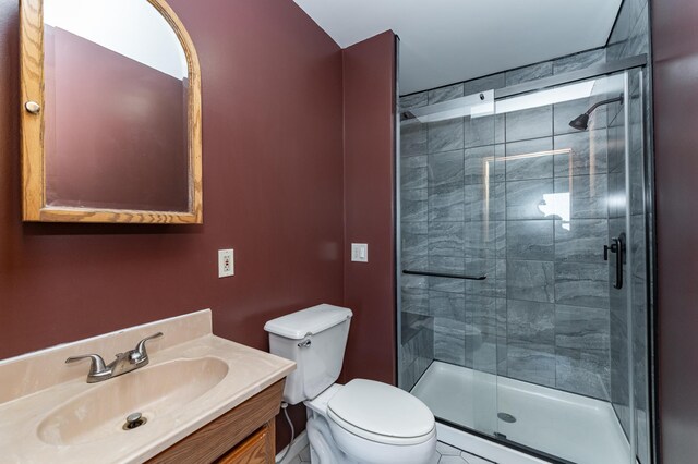 full bathroom featuring a stall shower, toilet, and vanity