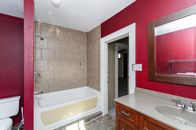 bathroom featuring toilet, vanity, shower / washtub combination, and a textured ceiling