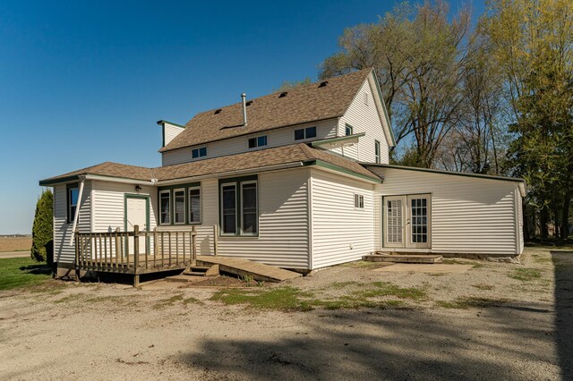 rear view of house with a deck and roof with shingles