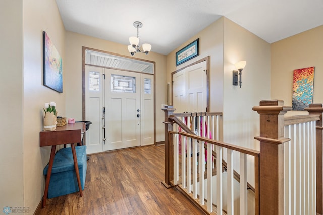 foyer with wood finished floors, a chandelier, and baseboards