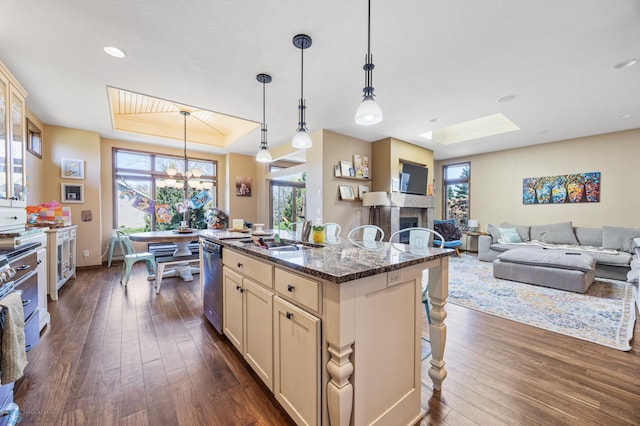 kitchen featuring dishwasher, dark wood-style floors, cream cabinetry, a sink, and recessed lighting