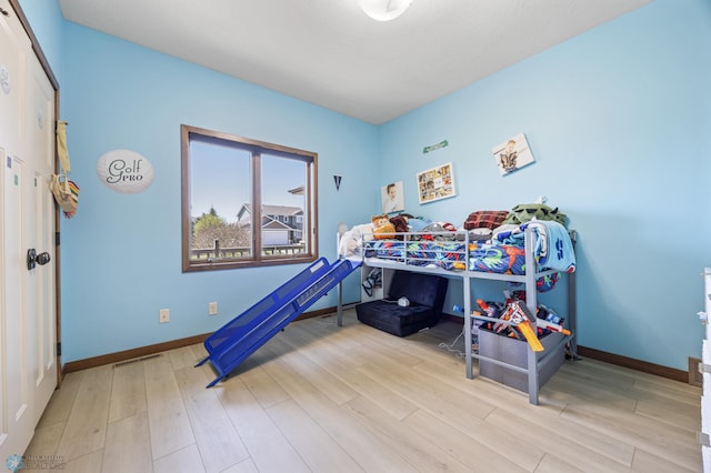 bedroom featuring wood finished floors and baseboards