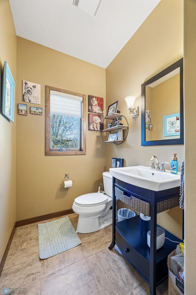 bathroom featuring toilet and baseboards