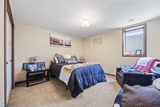 bedroom featuring carpet floors, baseboards, and a textured ceiling