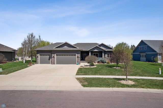 view of front of property with an attached garage, concrete driveway, and a front lawn