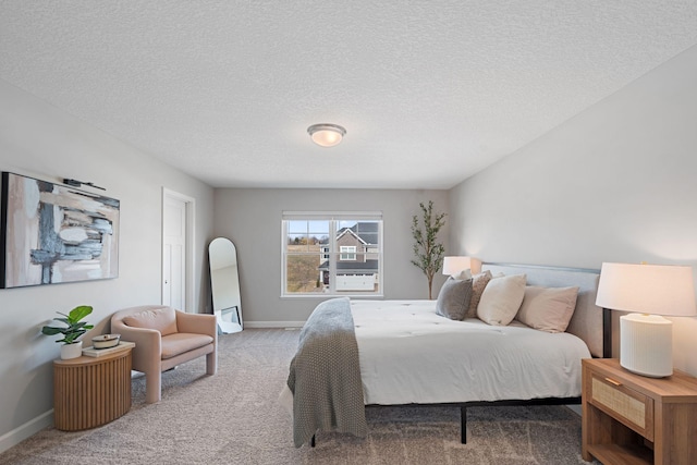 bedroom with a textured ceiling, baseboards, and carpet floors