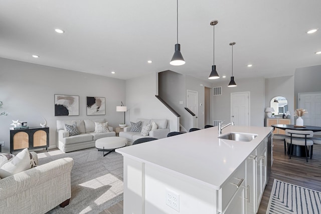 kitchen featuring a sink, open floor plan, recessed lighting, dark wood-style floors, and light countertops