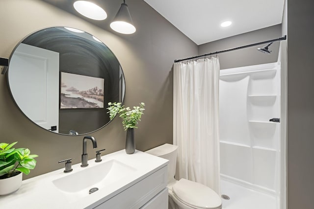 full bath with a shower stall, vanity, and toilet