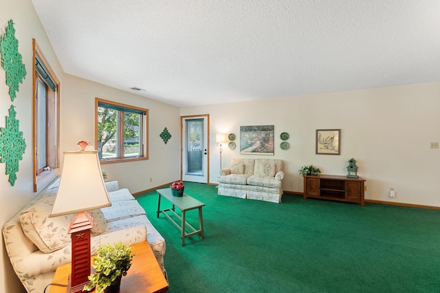 carpeted living area with a textured ceiling and baseboards