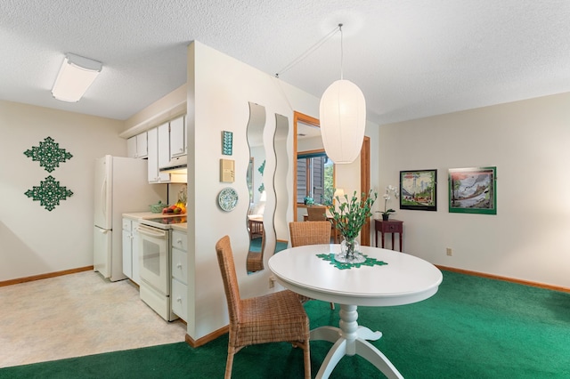 dining space with light colored carpet, baseboards, and a textured ceiling