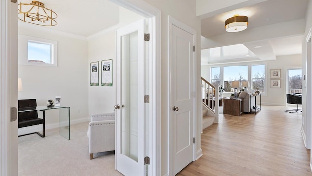 hall with stairway, baseboards, healthy amount of natural light, and ornamental molding