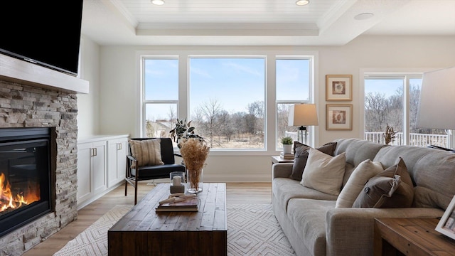 living room with a fireplace, a raised ceiling, healthy amount of natural light, crown molding, and recessed lighting