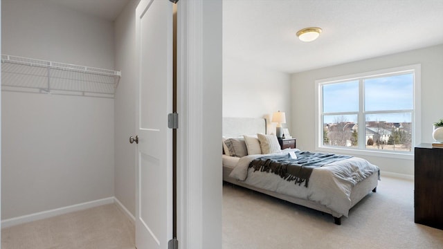 bedroom featuring light carpet and baseboards