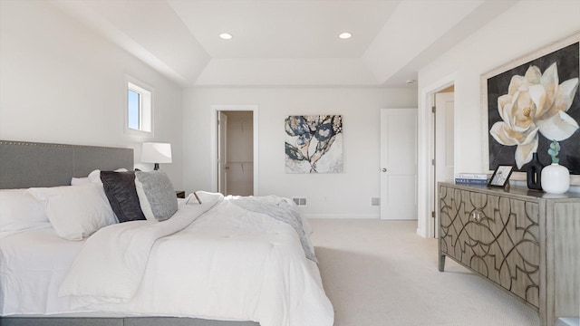 bedroom featuring a tray ceiling, light carpet, baseboards, recessed lighting, and a spacious closet