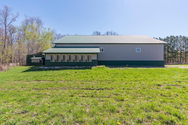 view of side of property featuring a lawn and metal roof