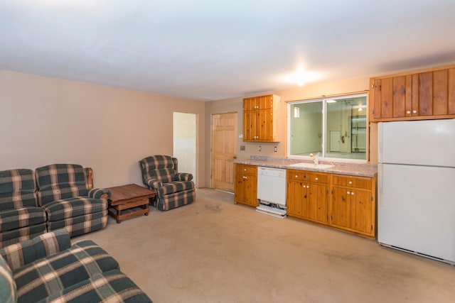 kitchen with white appliances, a sink, light countertops, brown cabinets, and light carpet