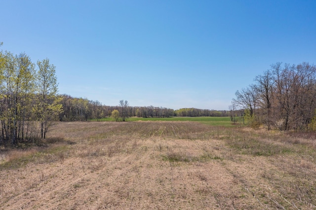 view of tree filled area featuring a view of rural / pastoral area