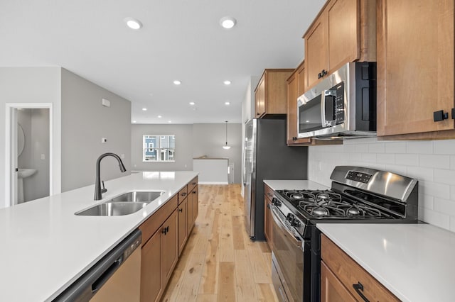 6750 Wildflower Way, Minnetrista, MN 55331 - kitchen with stainless steel appliances, a sink, light wood-style floors, light countertops, and decorative backsplash