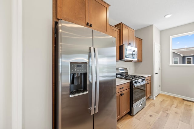 6750 Wildflower Way, Minnetrista, MN 55331 - kitchen with appliances with stainless steel finishes, decorative backsplash, light wood-style floors, baseboards, and light countertops