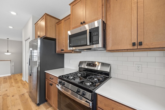 6750 Wildflower Way, Minnetrista, MN 55331 - kitchen with appliances with stainless steel finishes, decorative backsplash, brown cabinetry, light wood-type flooring, and recessed lighting