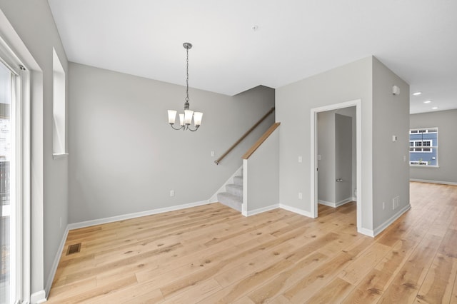 6750 Wildflower Way, Minnetrista, MN 55331 - unfurnished room featuring a chandelier, light wood-style floors, stairway, baseboards, and recessed lighting
