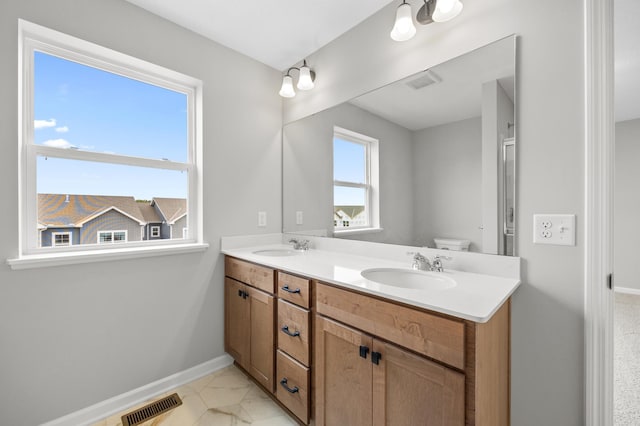 6750 Wildflower Way, Minnetrista, MN 55331 - bathroom featuring double vanity, baseboards, and toilet