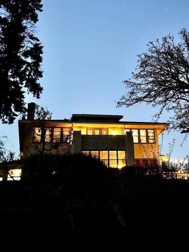 back of property with stucco siding and a balcony