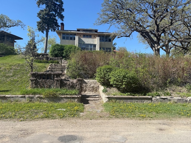 view of front facade with a chimney and stucco siding