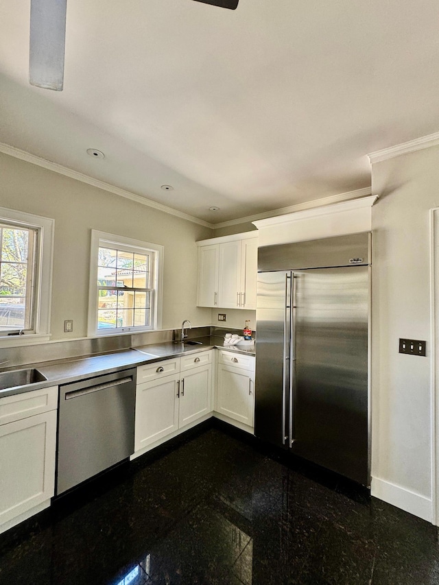 kitchen with stainless steel appliances, ornamental molding, granite tiled floors, a sink, and white cabinetry