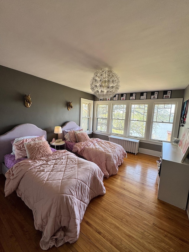 bedroom featuring radiator heating unit and wood finished floors