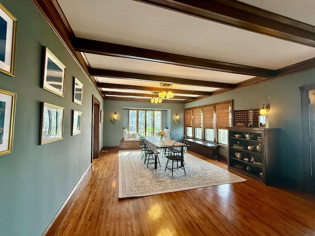 dining room featuring wood finished floors, baseboards, and beam ceiling