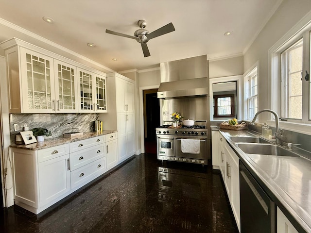 kitchen with wall chimney range hood, double oven range, a sink, dishwashing machine, and granite floors