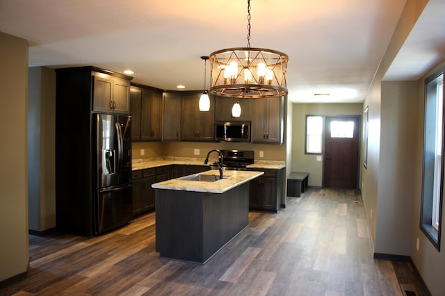 kitchen featuring dark wood-style flooring, appliances with stainless steel finishes, a sink, and dark brown cabinetry
