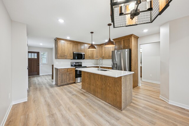 kitchen featuring appliances with stainless steel finishes, a sink, baseboards, light countertops, and recessed lighting