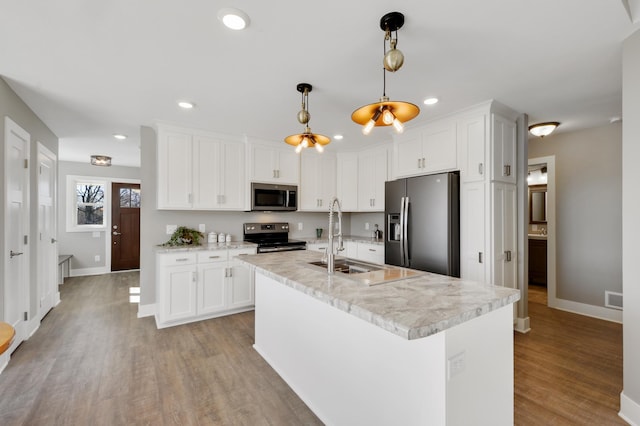 kitchen with stainless steel appliances, white cabinets, visible vents, and a sink
