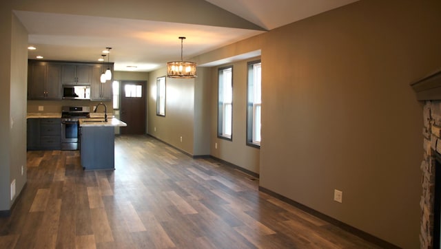 kitchen with stainless steel gas range oven, an inviting chandelier, a sink, white microwave, and light countertops