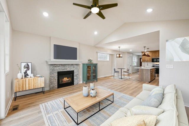 living room with light wood finished floors, ceiling fan, lofted ceiling, baseboards, and recessed lighting