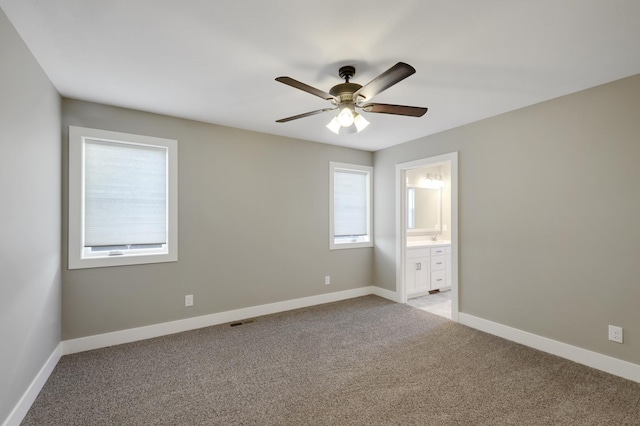 unfurnished bedroom with light colored carpet, baseboards, and connected bathroom